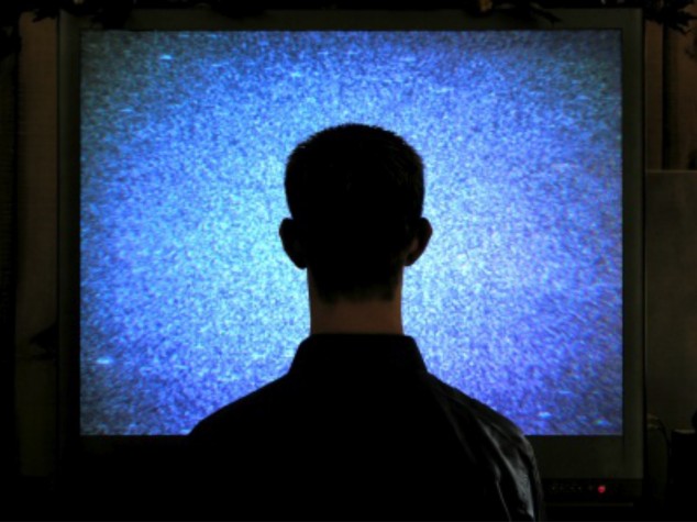 Silhouette of head in front of blank TV screen